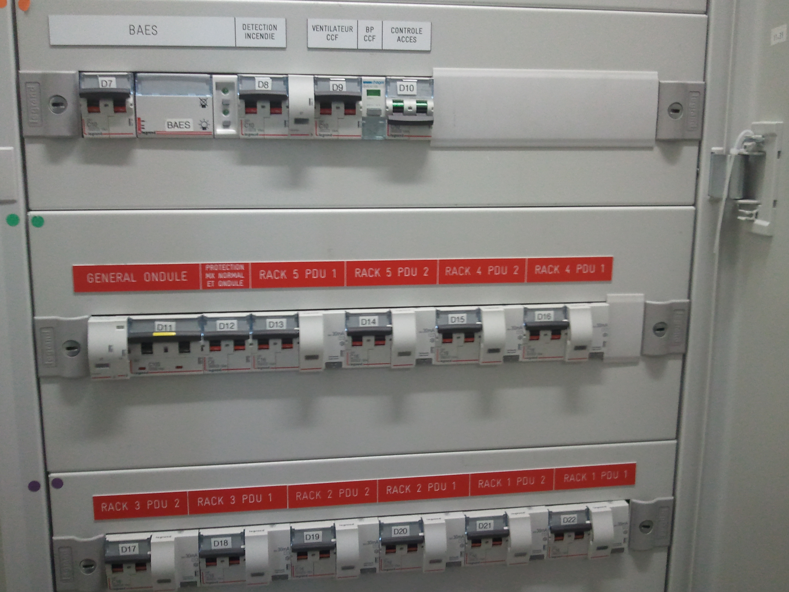 Panneau électrique avec disjoncteurs et étiquettes.