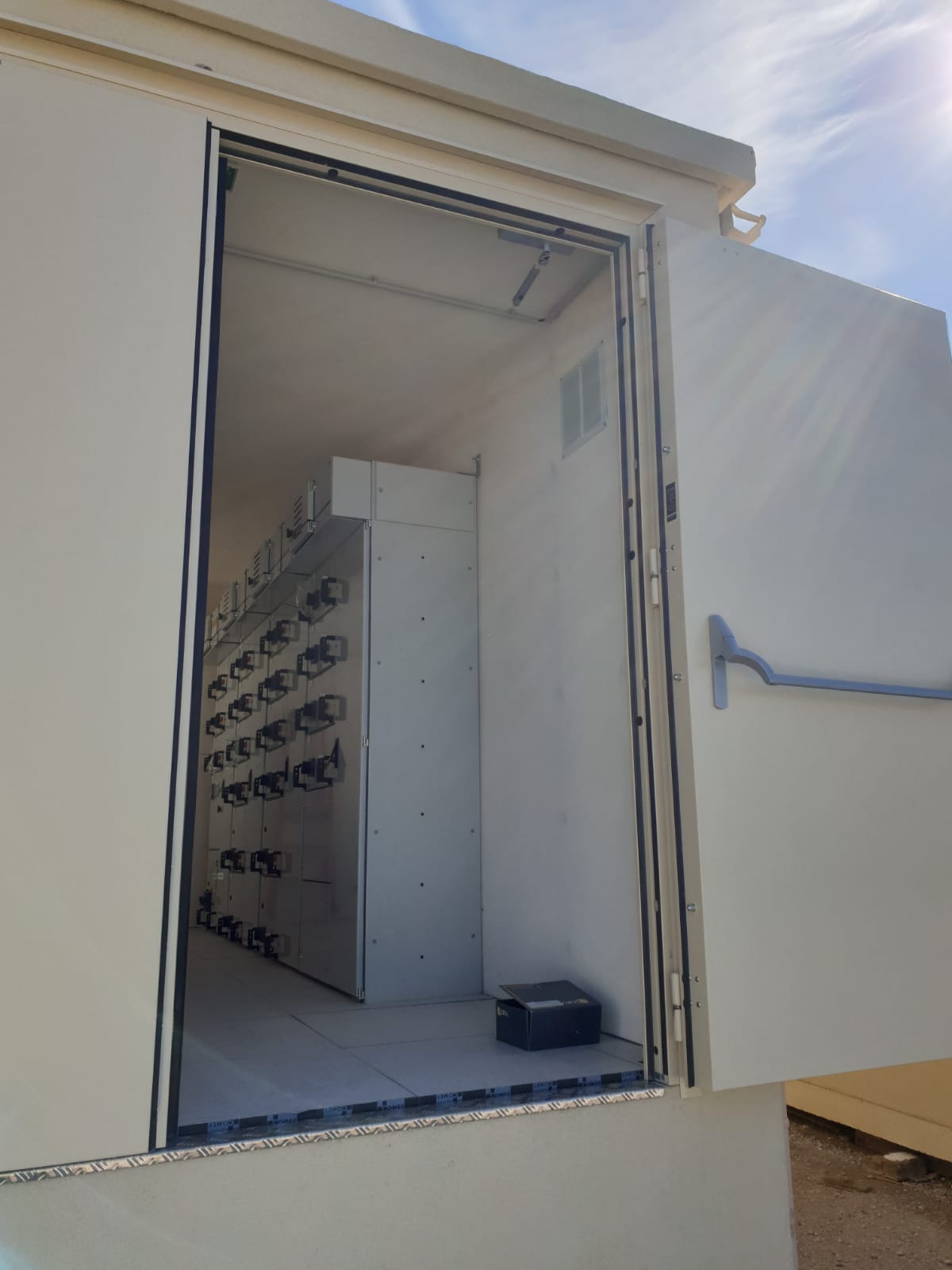 Armoire électrique ouverte avec équipements à l'intérieur.